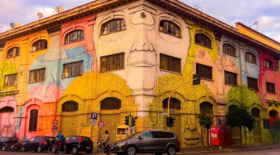 Murales di Blu su Via del Porto Fluviale a Ostiense, con i volti dipinti sulle finestre
