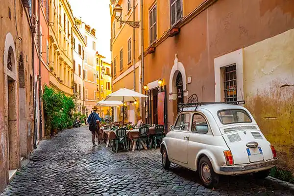 Vicolo di Trastevere con una Fiat 500 d'epoca tra i palazzi